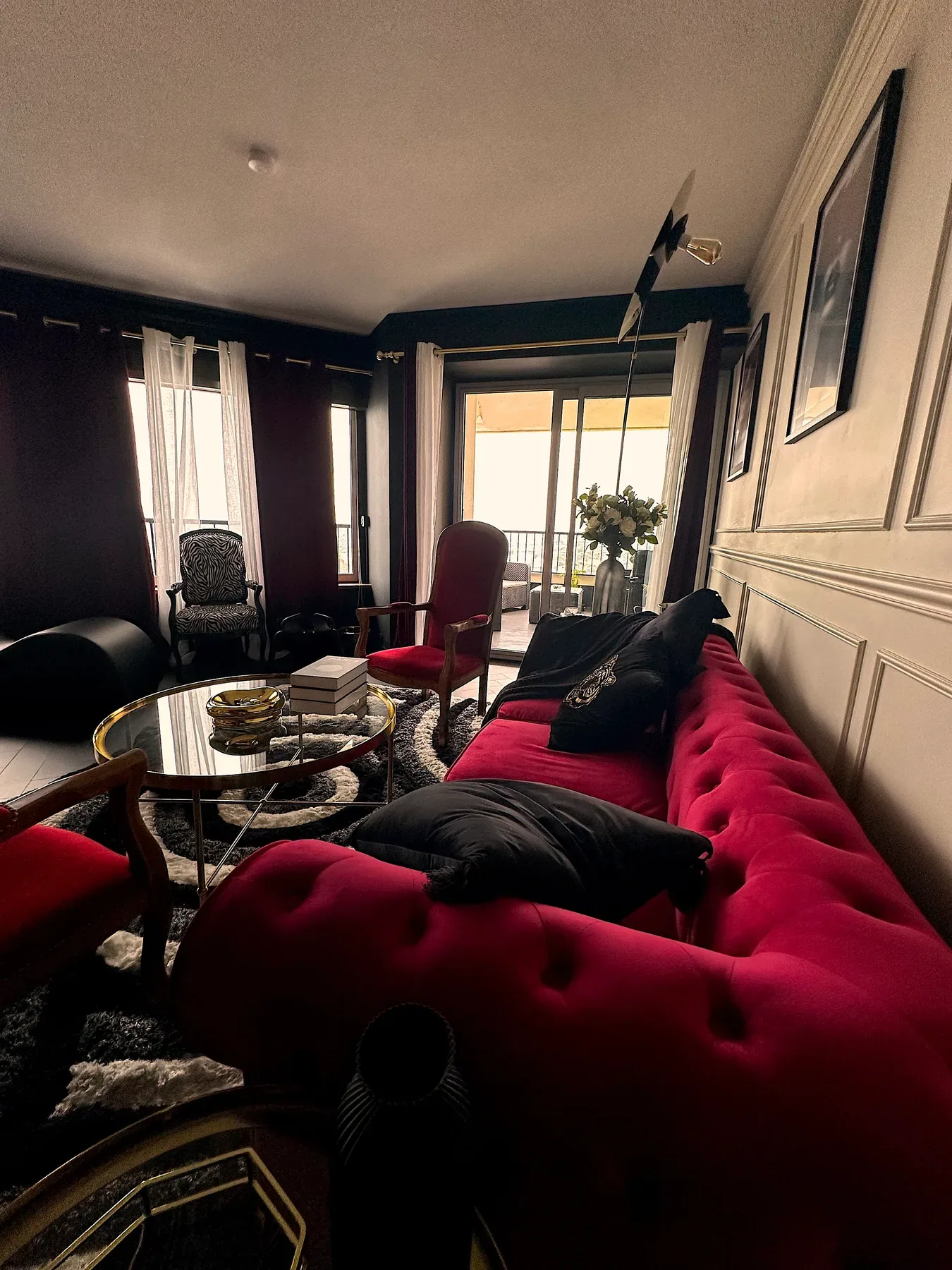 Salon en velours bordeaux et balcon à la lumière du jour